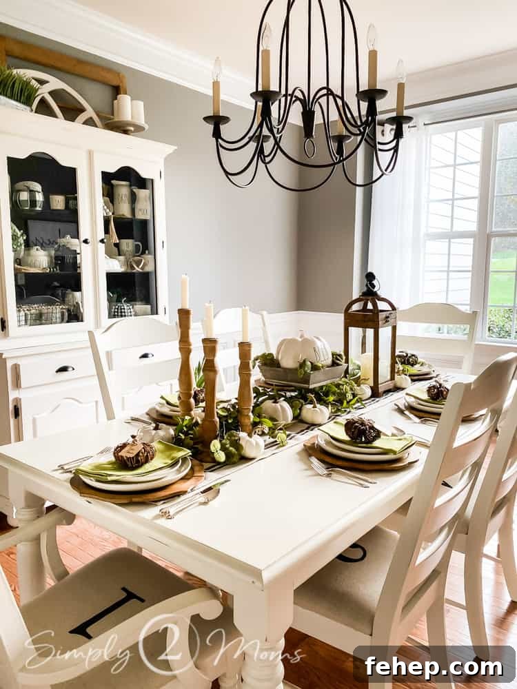 dining room with table and six chairs chandilier hanging over table and china cabinet to left of table windows at far end of room