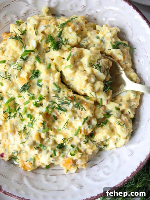 Classic Cape Cod Chicken Salad Recipe for Summer Lunches 11 Cottage cheese egg salad in a bowl garnished with chives served with a spoon.