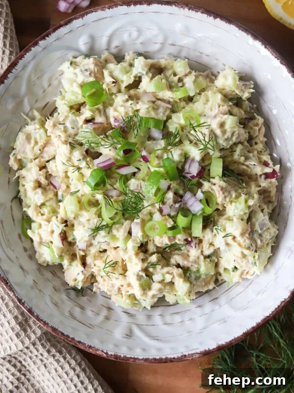 Classic Cape Cod Chicken Salad Recipe for Summer Lunches 12 Cottage cheese tuna salad garnished with herbs and red onion in a bowl.
