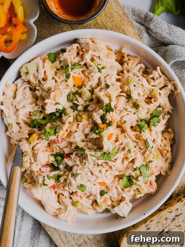 Classic Cape Cod Chicken Salad Recipe for Summer Lunches 13 A serving spoon in a bowl of spicy chicken salad.
