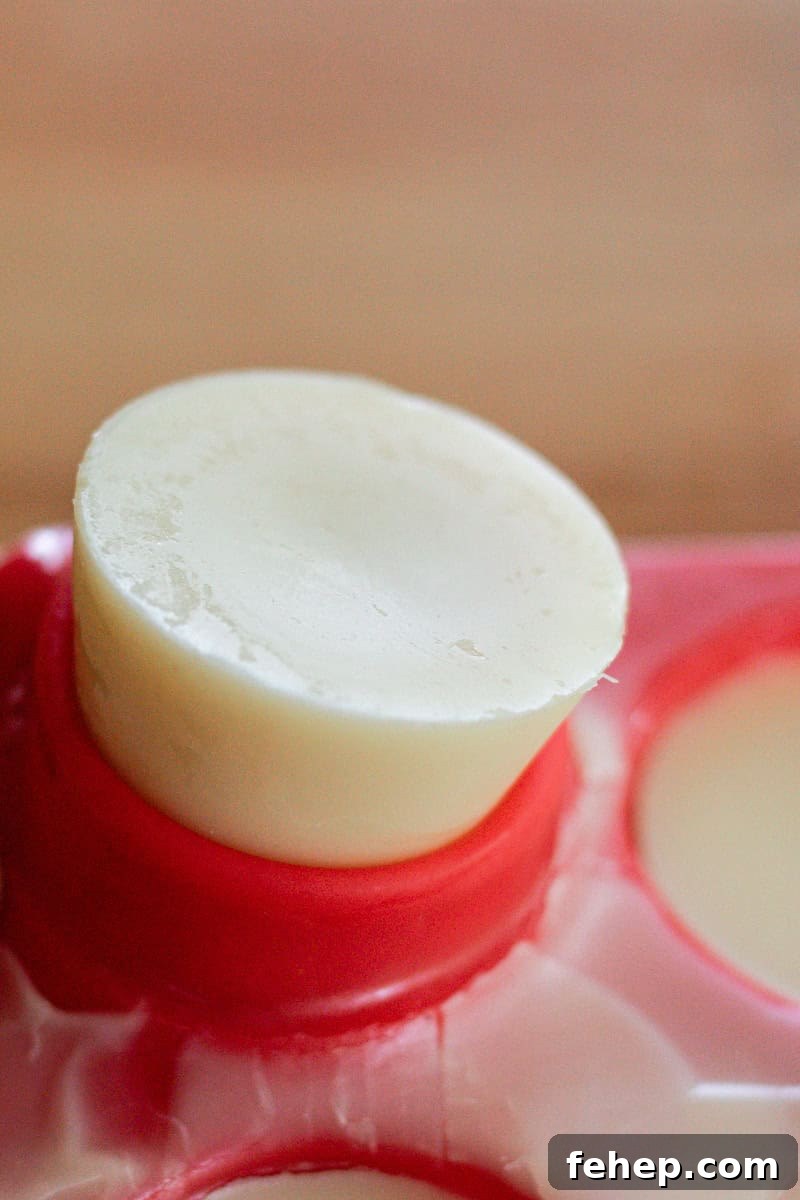 A lotion bar being popped out of a silicone mold after hardening completely. 