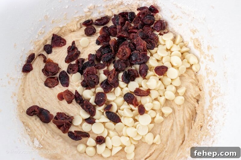 stirring dried cranberries and white chocolate chips into bread batter