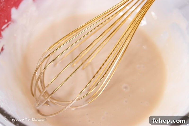 mixing icing with wire whisk