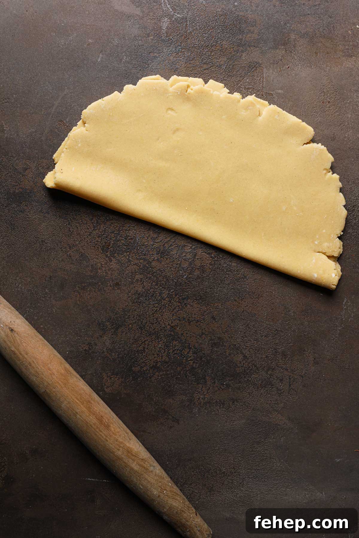Italian Pasta Frolla Shortcrust Pastry: Multipurpose Dough Guide 14 Rolled dough folded over itself next to a rolling pin.