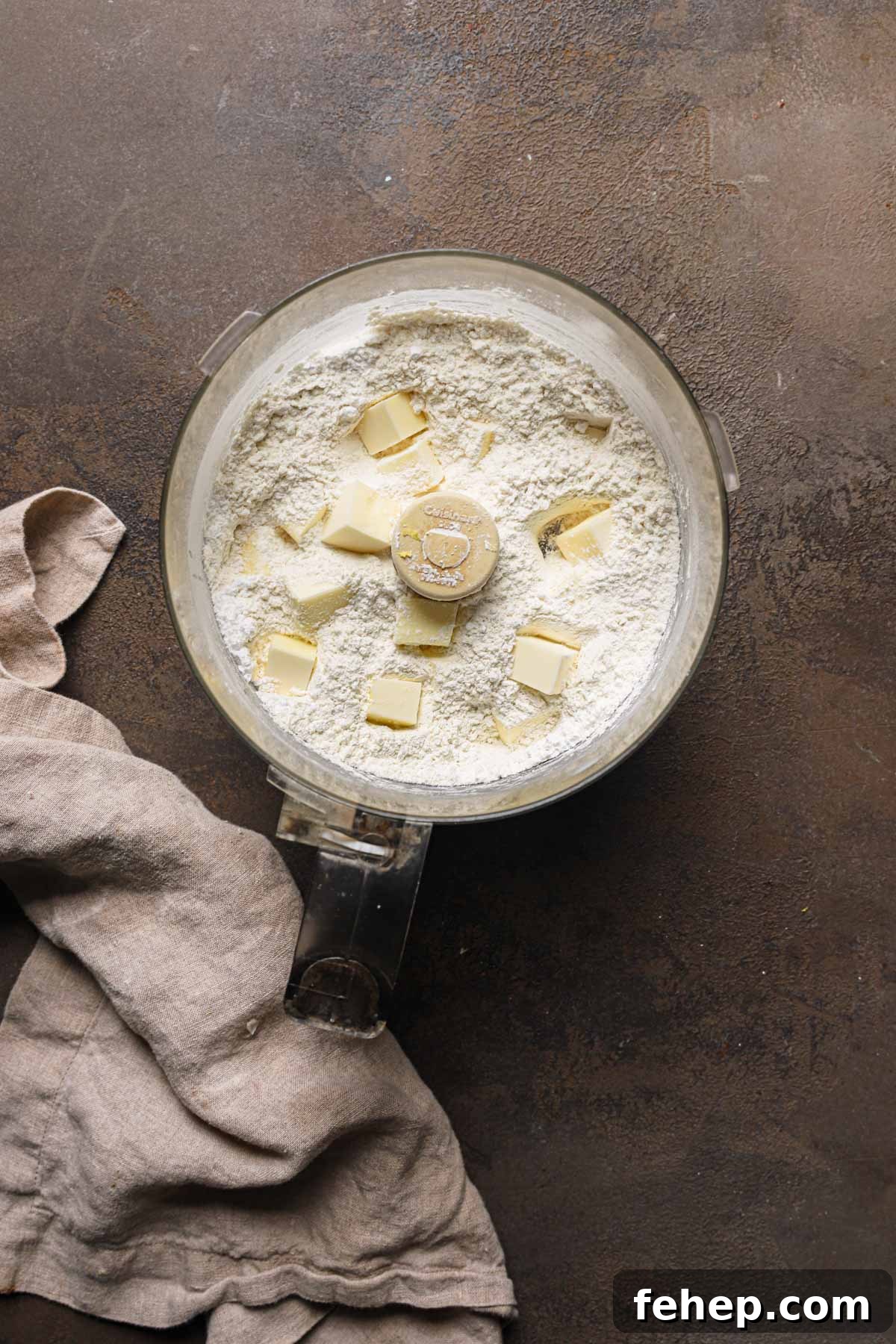 Italian Pasta Frolla Shortcrust Pastry: Multipurpose Dough Guide 4 A food processor bowl with flour and pieces of butter.