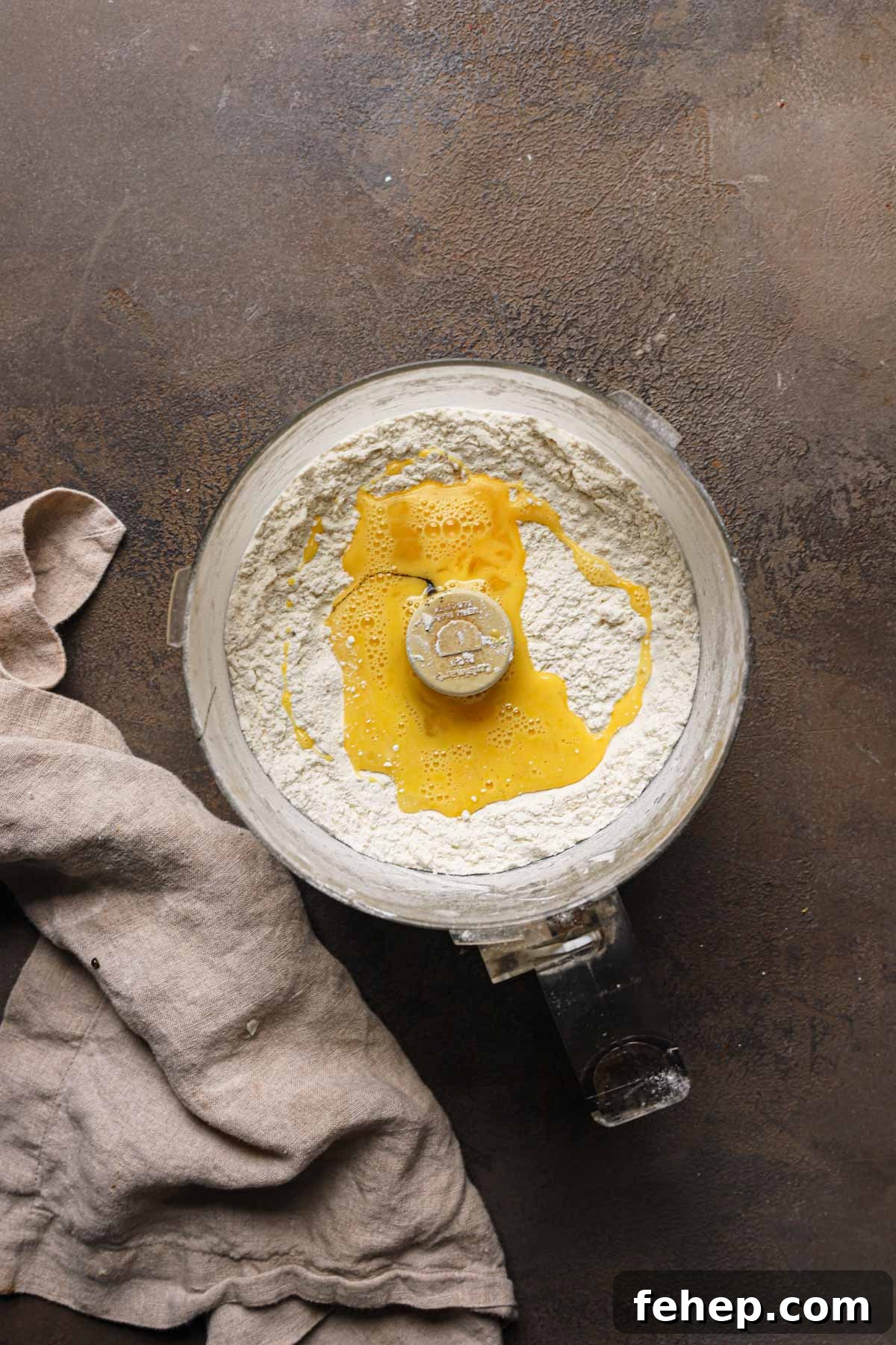 Italian Pasta Frolla Shortcrust Pastry: Multipurpose Dough Guide 5 A bowl of a food processor with flour and beaten egg.