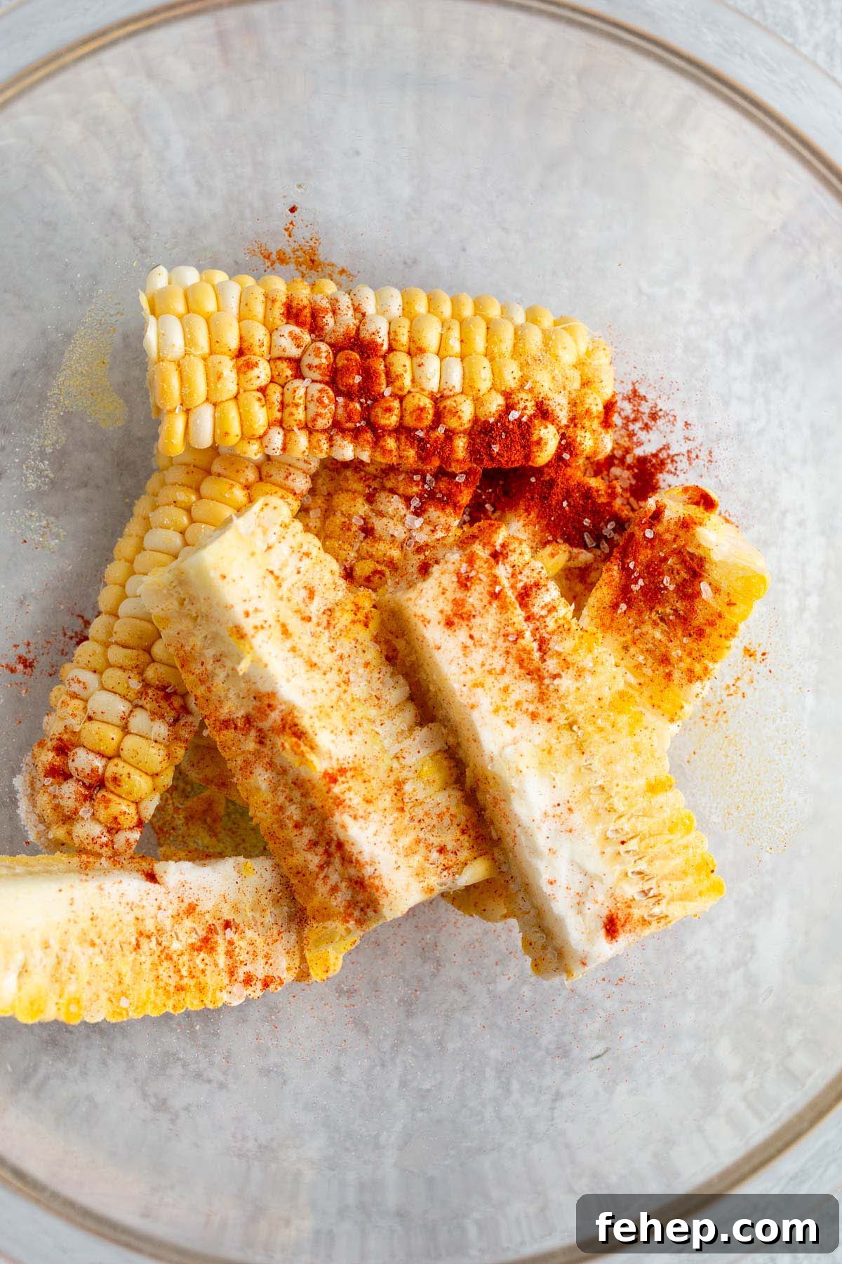 Crispy Air Fryer Corn Ribs Recipe for Summer BBQs 5 Corn ribs with seasonings in a large bowl.