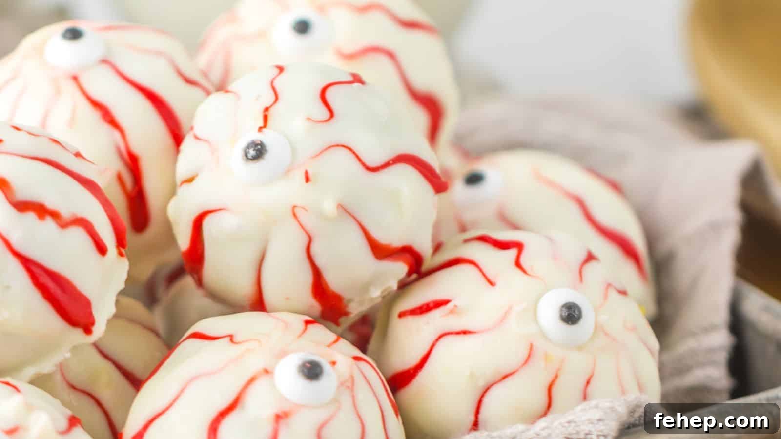 11 Spooky Halloween Treats to Liven Up Any October Night 8 A pile of white chocolate covered truffles decorated to look like spooky Halloween eyeballs, complete with red veins and a candy eyeball in the center.