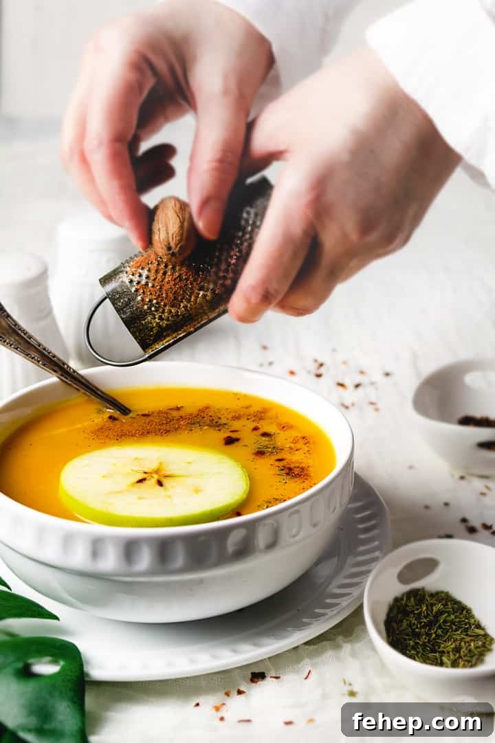 Butternut Squash and Apple Soup Recipe for Cozy Fall Nights 5 Grating a whole nutmeg over a bowl of squash soup