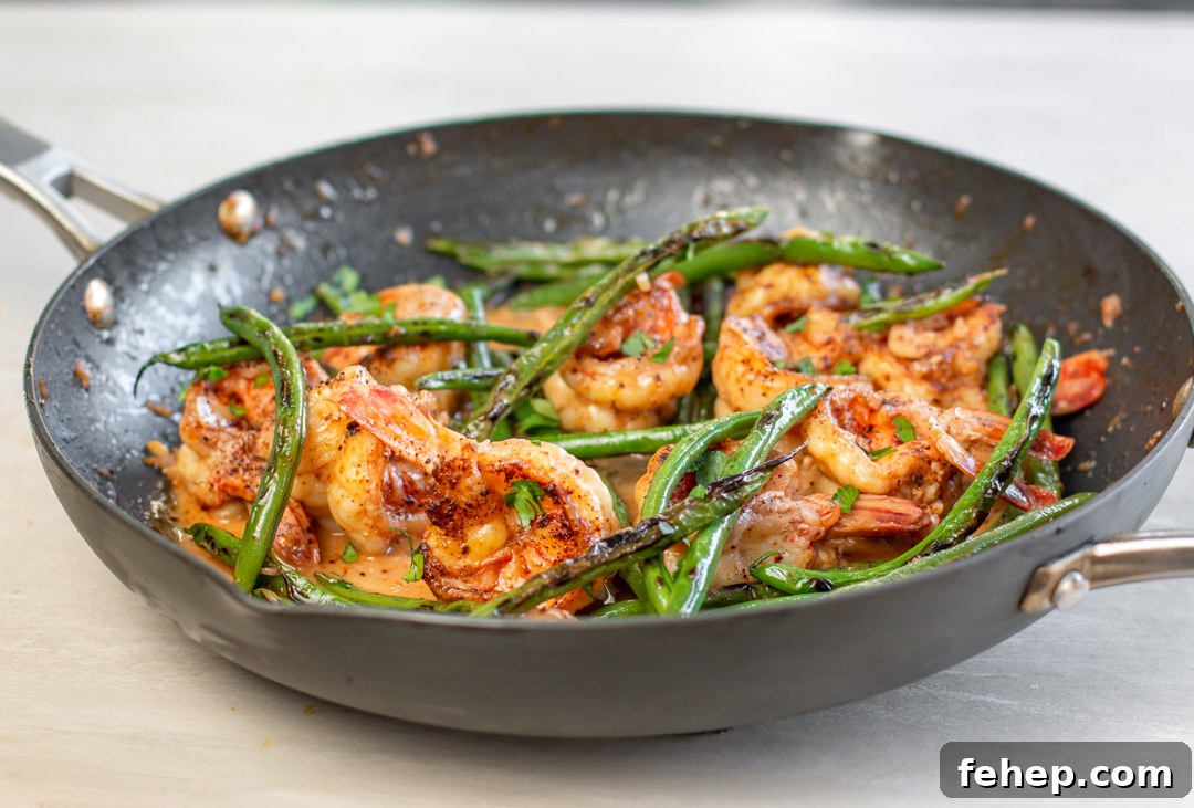 Blackened green beans are added to the pan of shrimp and blood orange sauce