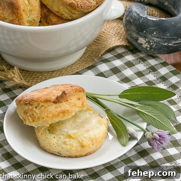 Herbed Buttermilk Biscuits - Tender, buttery biscuits with a boost of flavor from fresh herbs Herbed Buttermilk Biscuits on a white plate with sage and chives.