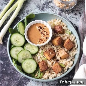 Flavorful Marinated Baked Tofu Recipe for Crispy, Savory Tofu 13 Oven baked tofu finished dish with rice, cucumbers, and sauce.