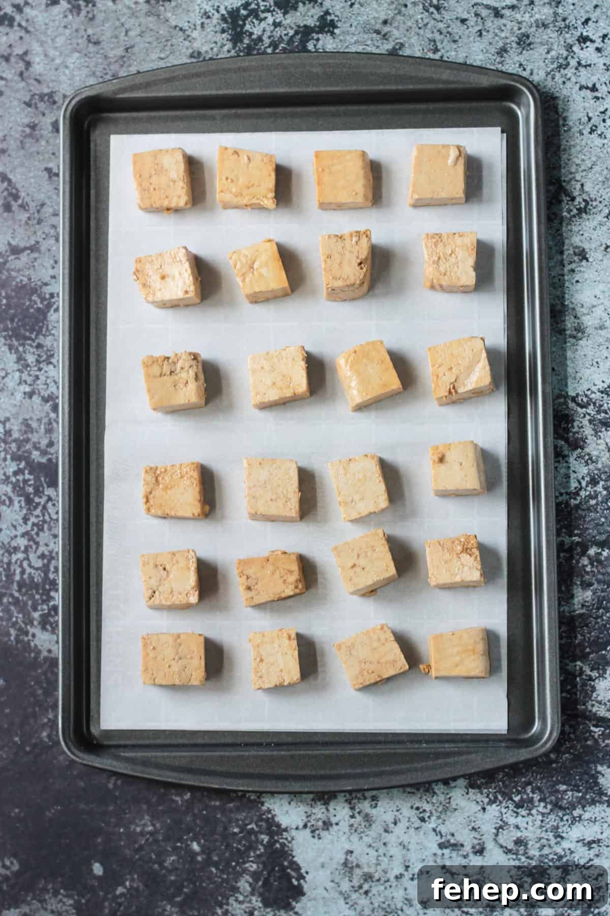 Flavorful Marinated Baked Tofu Recipe for Crispy, Savory Tofu 6 marinated tofu cubes on a sheet pan ready to go in the oven