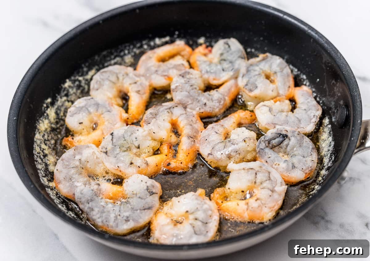 cooking coated shrimp in skillet.