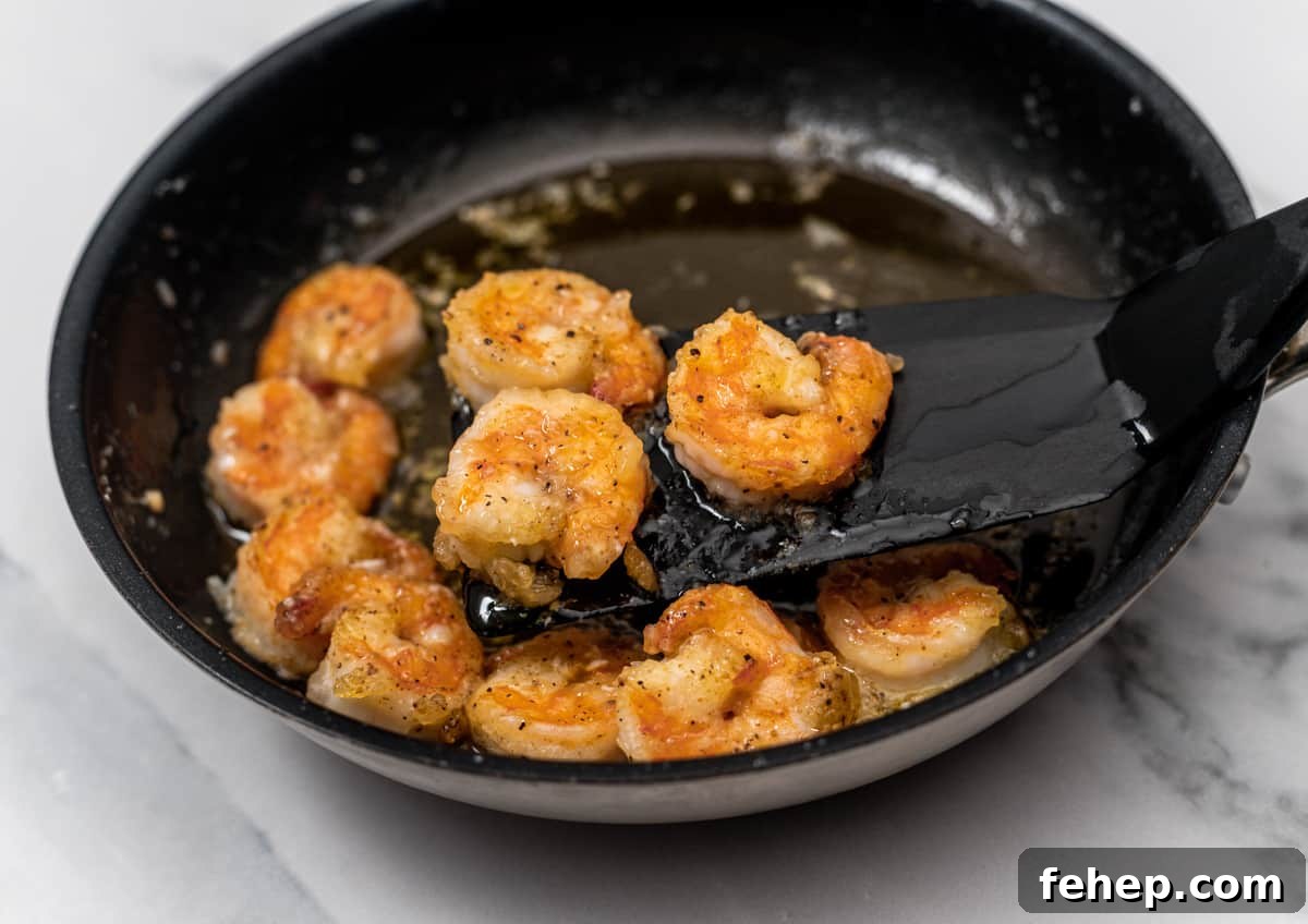 removing cooked shrimp from skillet.