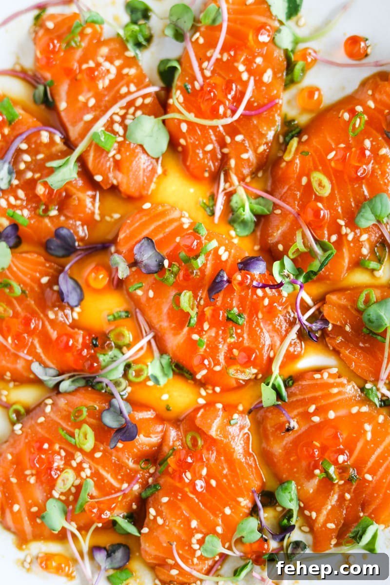 Buttery miso salmon crudo (carpaccio) with ikura, scallions, micro greens, and ikura in a miso-shoyu dressing.