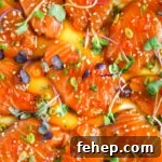 Buttery miso salmon crudo (carpaccio) with ikura, scallions, micro greens, and ikura in a miso-shoyu dressing.