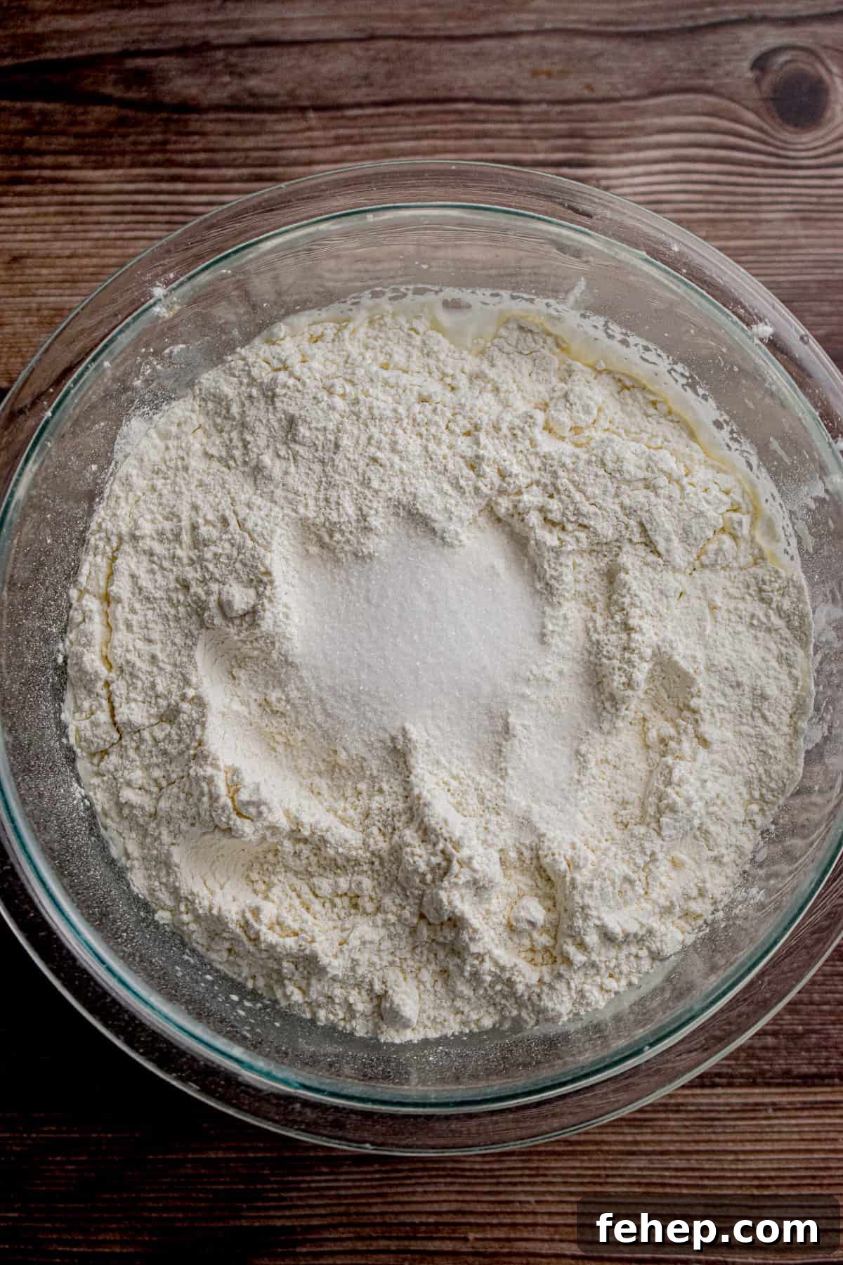 The salt and flour are added to a glass bowl.