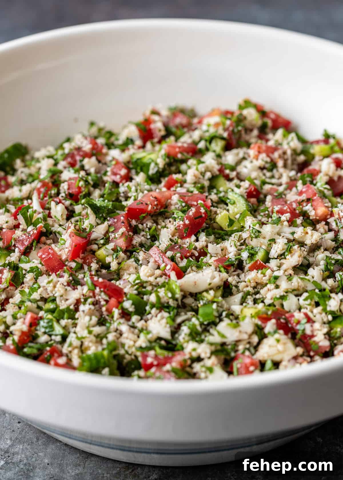Cauliflower Tabbouleh Salad with Fresh Herbs and Lemon Vinaigrette 3 a large white bowl full of cauliflower tabbouleh