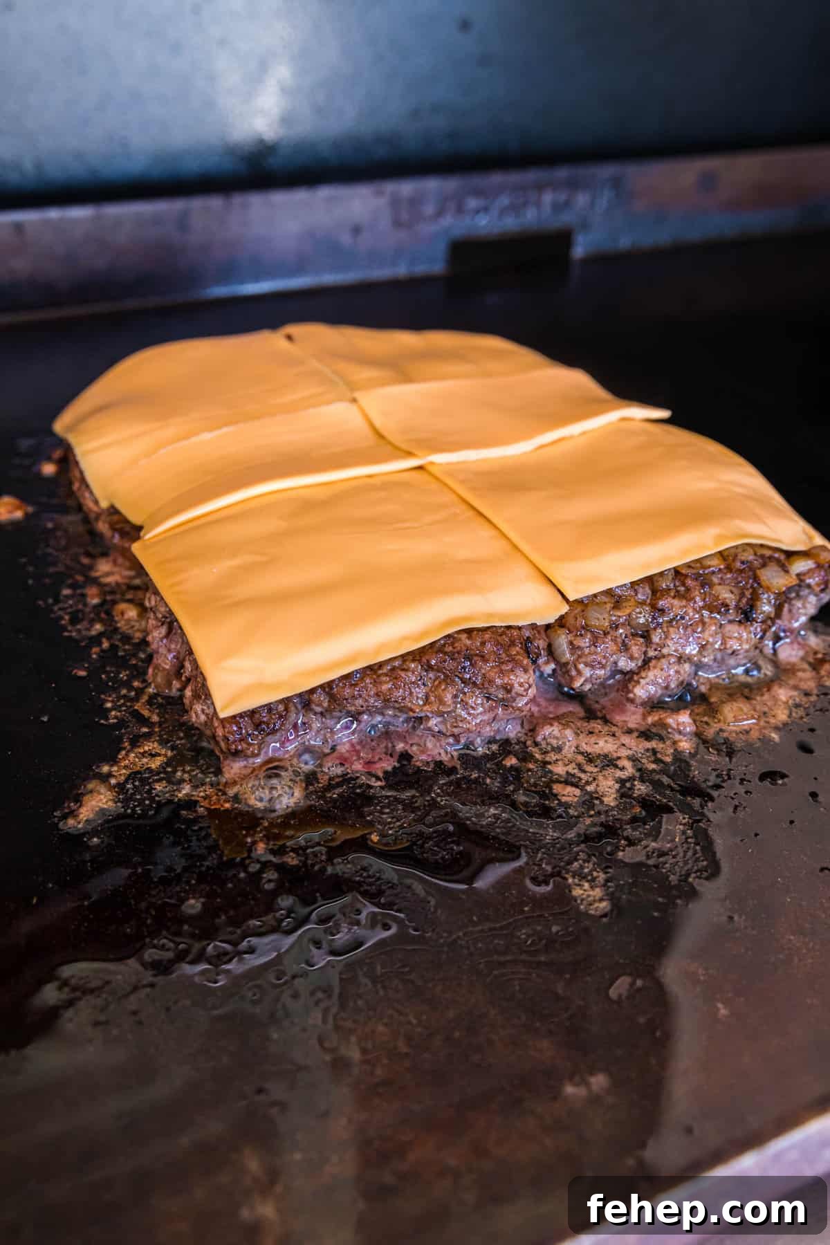 Topping Ground Beef with American Cheese for Blackstone Bacon Cheeseburger Sliders Recipe