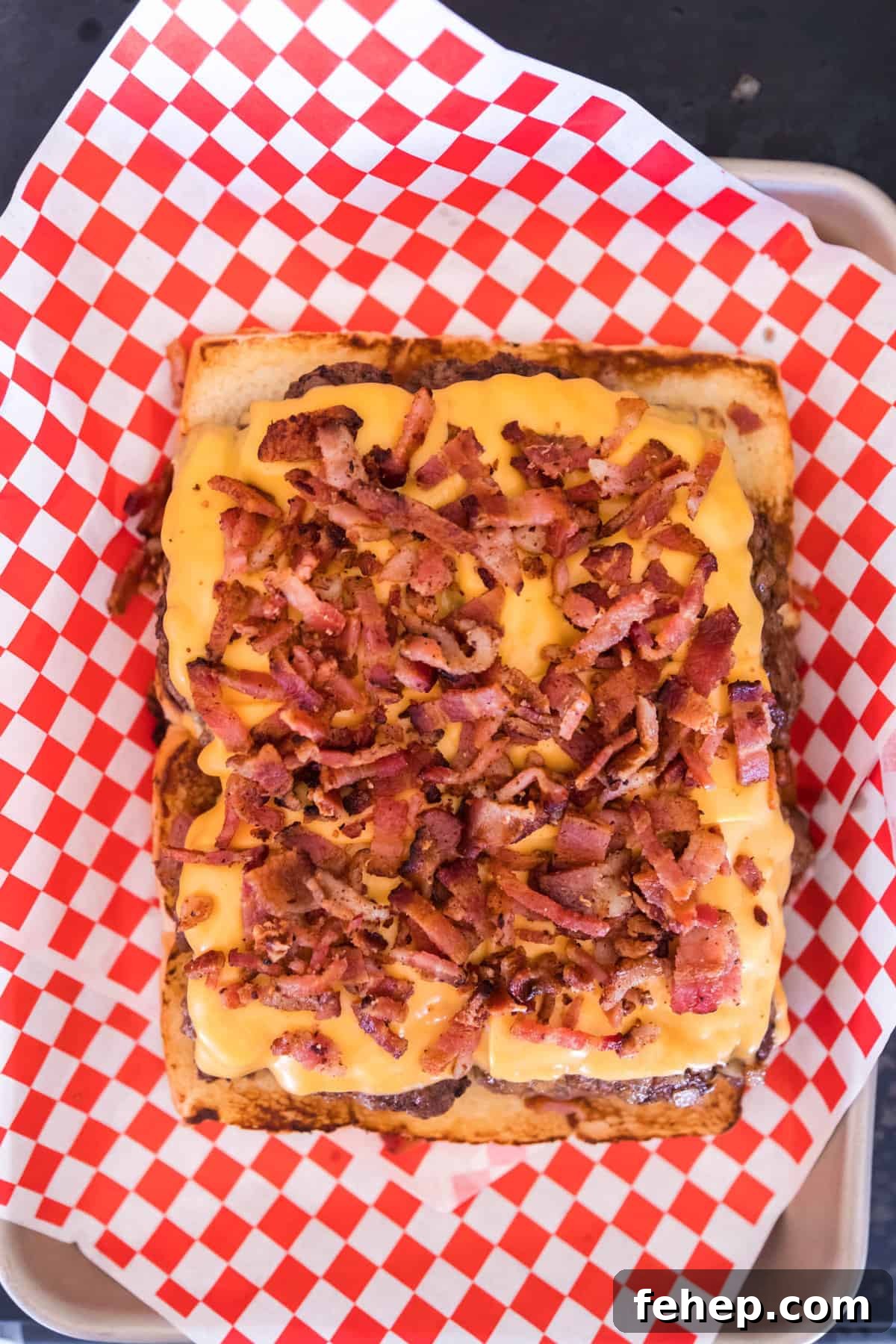 Topping Ground Beef and Cheese with Grilled and Crumbled Bacon
