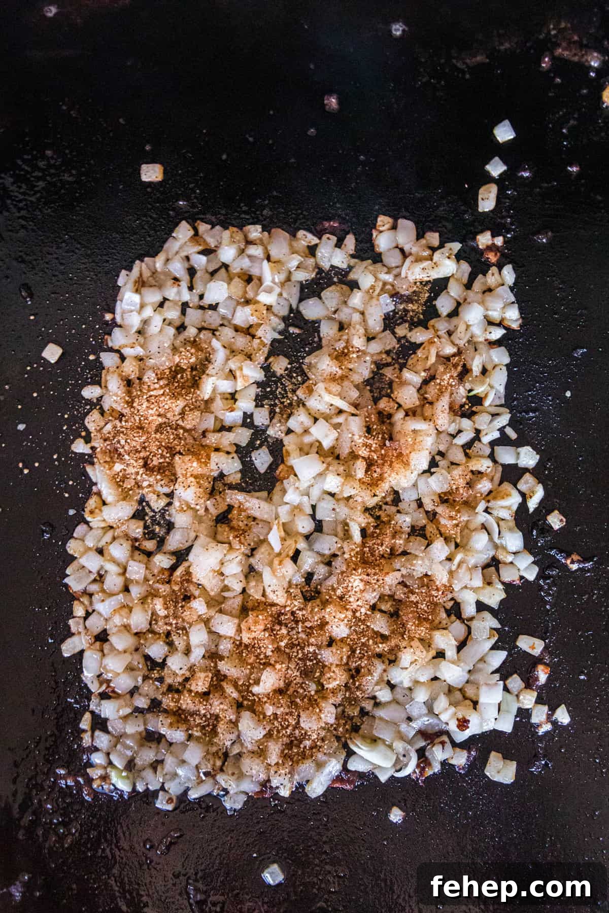Cooking Seasoned Diced Onions on Blackstone for Sliders