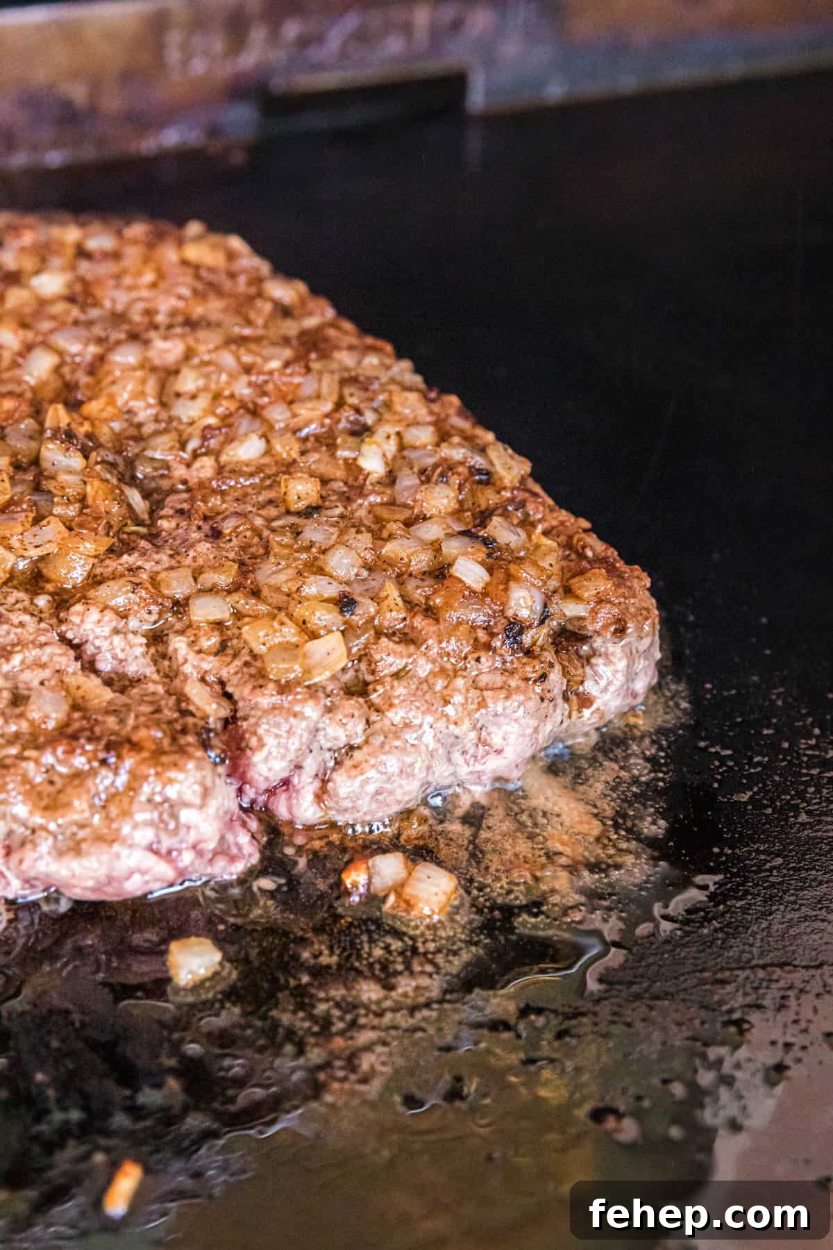 Cooking Ground Beef and Onions on Blackstone for Bacon Cheeseburger Sliders