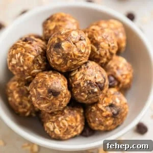 White ceramic bowl with peanut butter oatmeal energy bites with chocolate chips and oats scattered around the bowl.