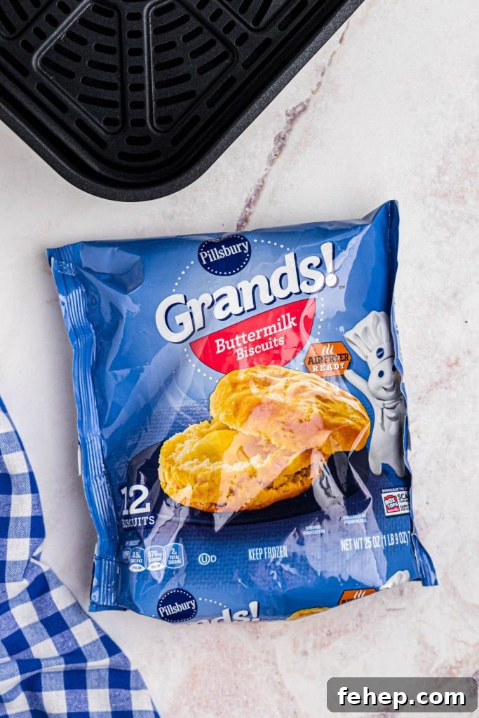 Crispy Air Fryer Frozen Biscuits in Minutes 3 Frozen package of biscuits in front of an air fryer basket.
