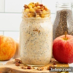 Creamy yogurt mixed with oats and apple slices in a mason jar making apple pie overnight oats.
