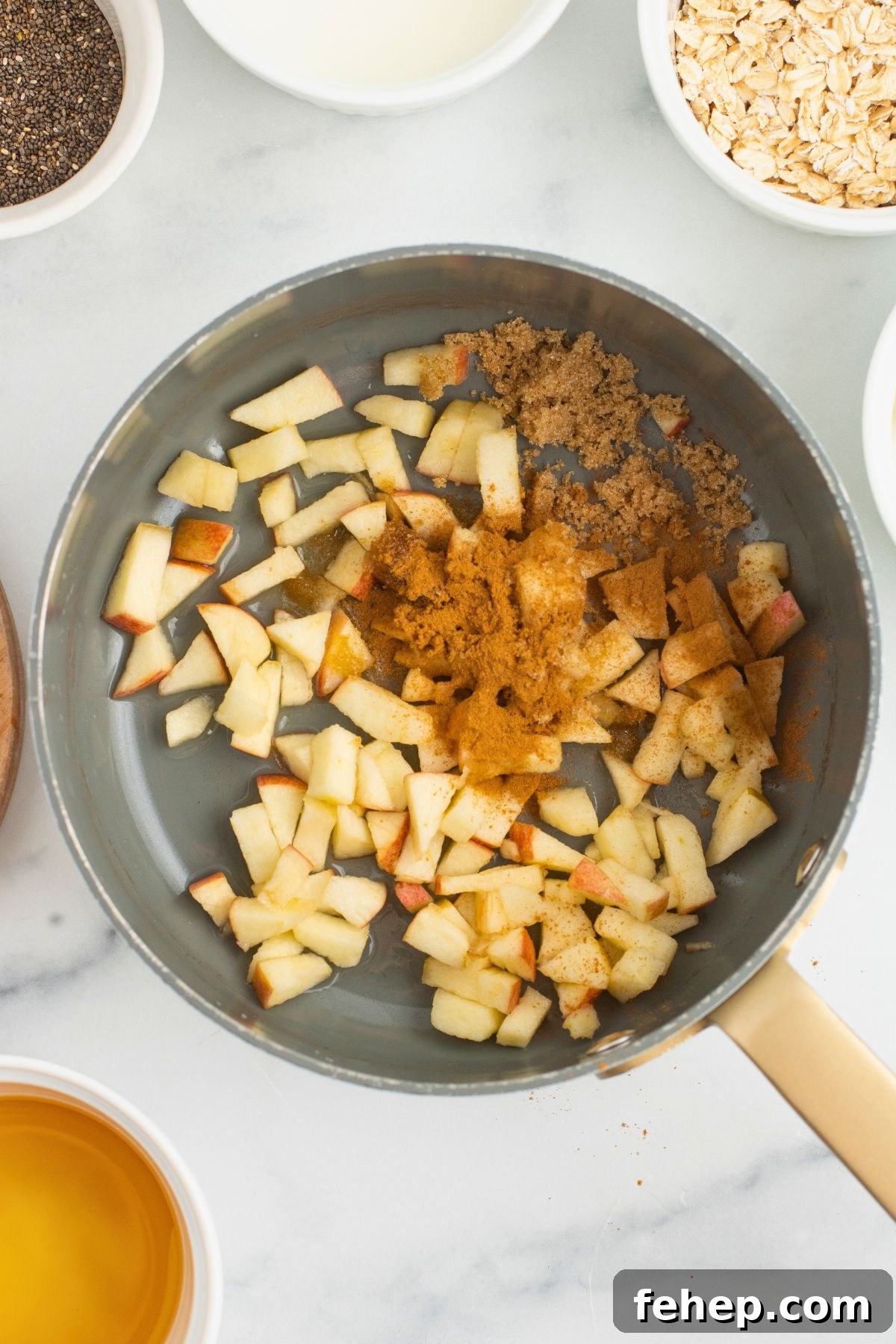Apples and spices in a saucepan before being cooked to soften. 