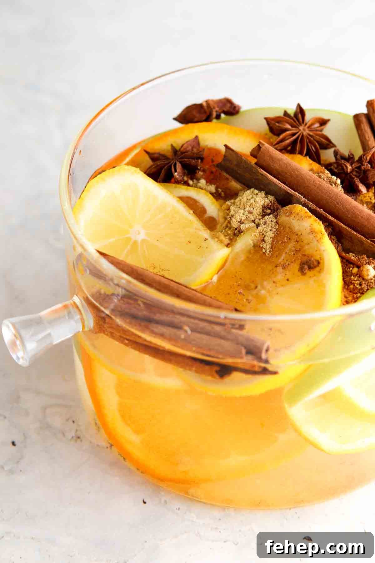Cozy Fall Simmer Pot Recipe for a Home-Filling Autumn Scent 2 Lemons, apples, oranges, and cinnamon in a pot.