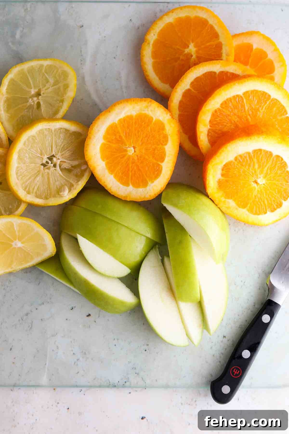 Cozy Fall Simmer Pot Recipe for a Home-Filling Autumn Scent 4 Apples, oranges and lemons on a cutting board.