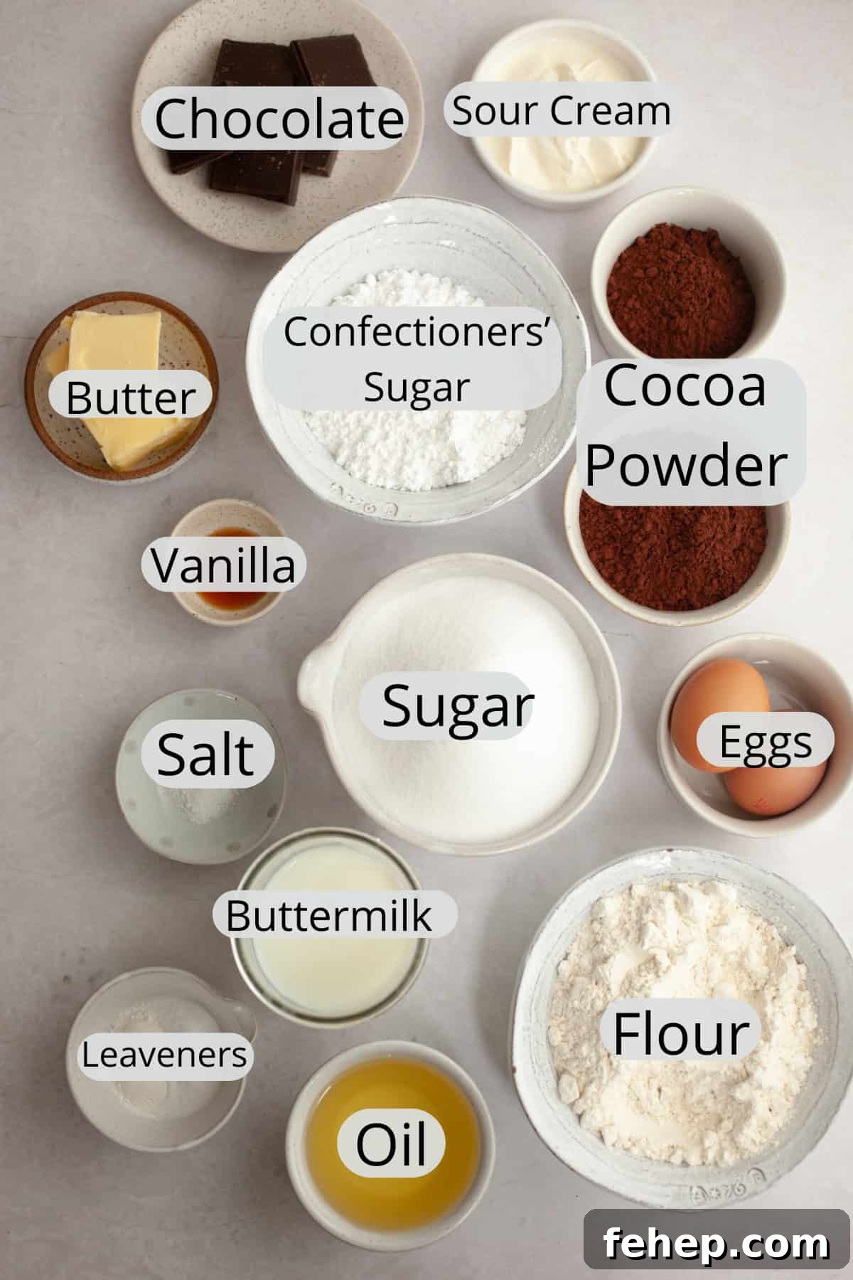 All the ingredients needed to make a single layer chocolate cake with chocolate sour cream frosting, weighed out into small bowls.