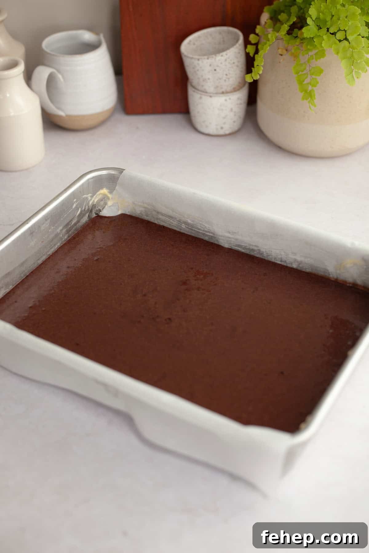 Unbaked chocolate cake in a rectangular pan.