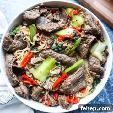 Stir-Fried Vietnamese Pho with Beef and Noodles 12 white plate with noodles, vegetables, and beef.