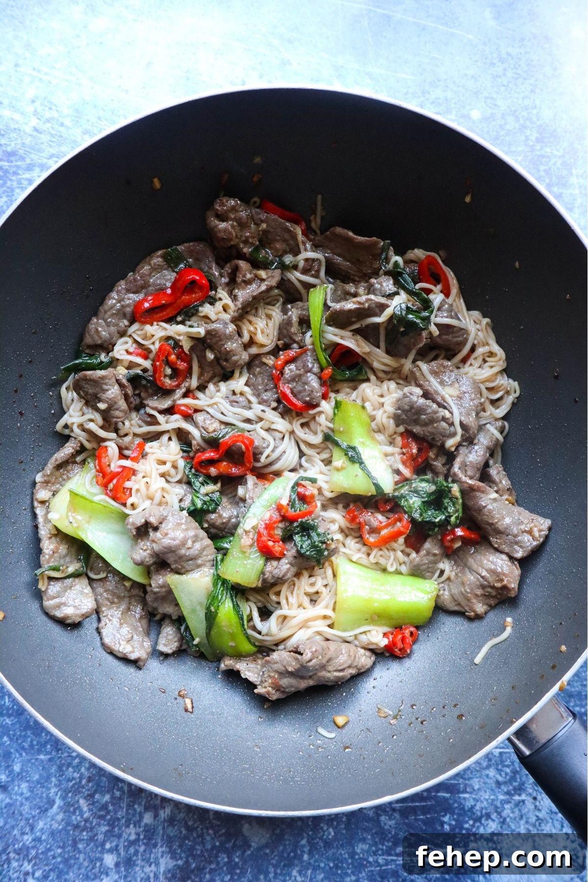 Stir-Fried Vietnamese Pho with Beef and Noodles 6 wok with stir fry beef, noodles, and vegetables cooked in a wok together.