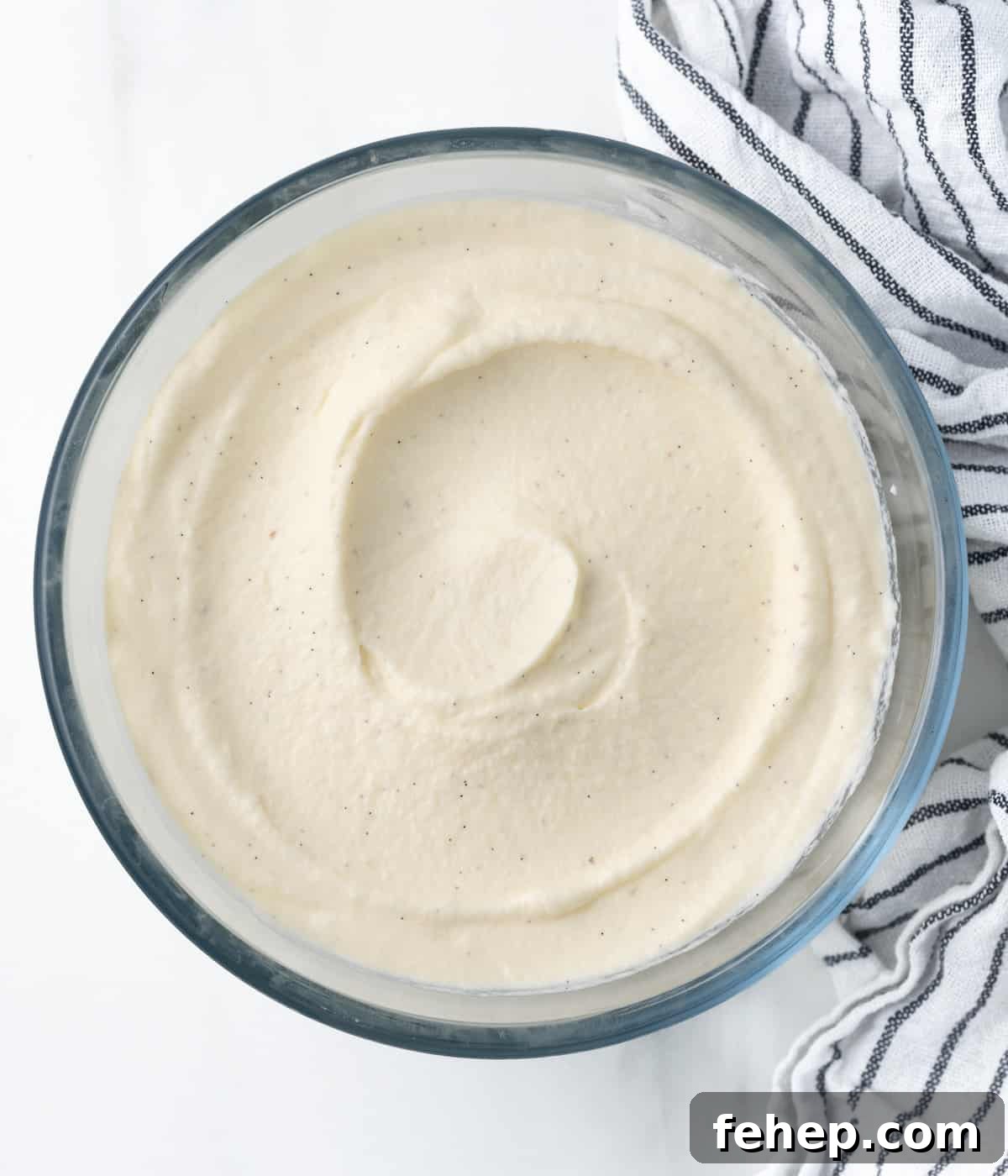 How to Make Classic Chantilly Cream (Crème Chantilly) 9 Cream spread in a glass mixing bowl seen from above.