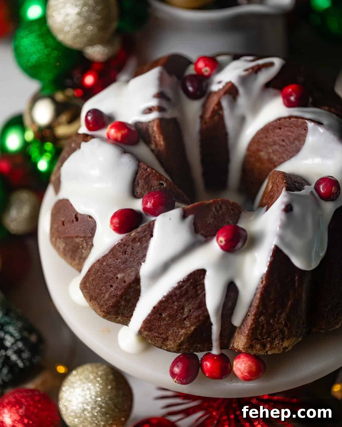 gingerbread bundt cake topped with cream cheese frosting and cranberries.