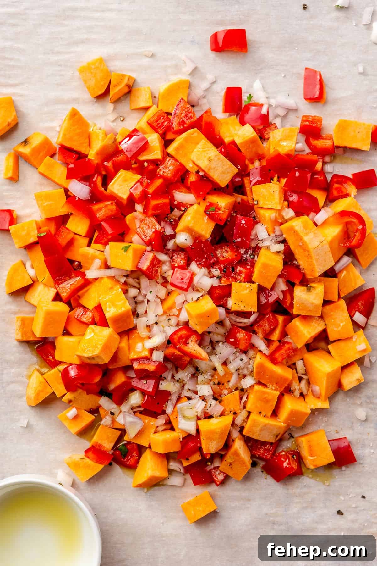 Make-Ahead Breakfast Burritos for Busy Mornings 4 Diced sweet potato, bell peppers, and shallot piled on a parchment-lined sheet pan.