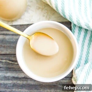 A bowl of coconut condensed milk with a spoon in it.