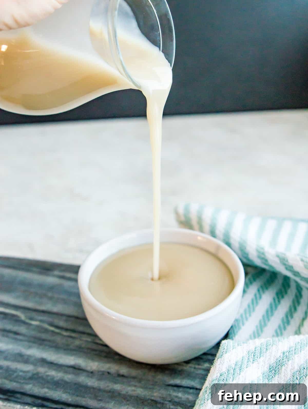 A bowl with condensed milk being poured into it.