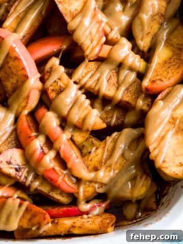 A pan filled with baked apple slices topped with a caramel sauce.