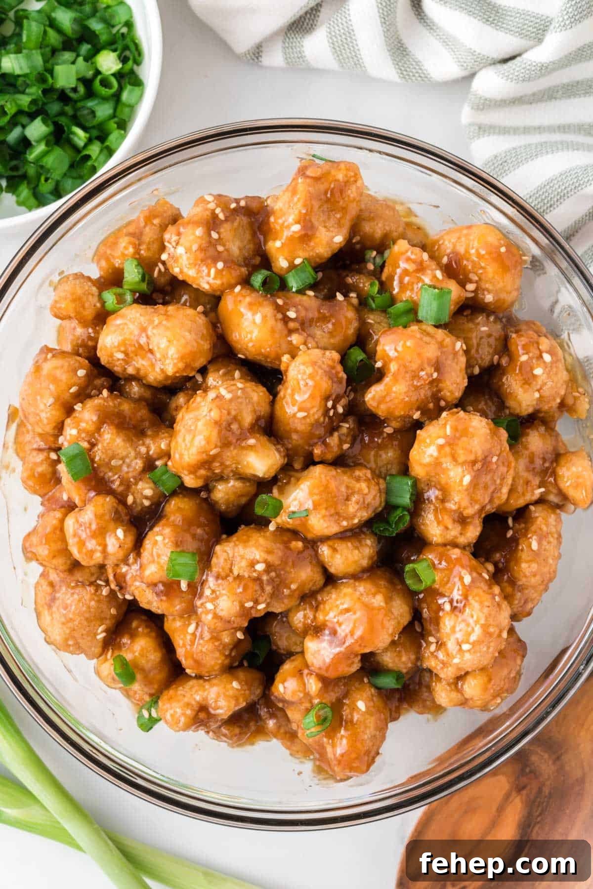 Sticky Teriyaki Cauliflower Bites with Sesame and Scallions 13 teriyaki cauliflower in a bowl topped with green onions and sesame seeds