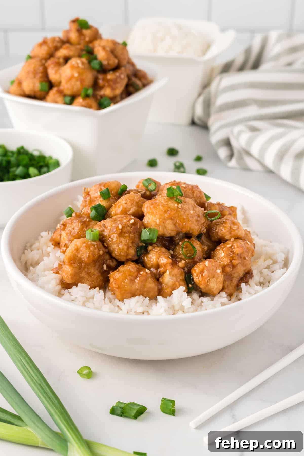 Sticky Teriyaki Cauliflower Bites with Sesame and Scallions 14 teriyaki cauliflower over rice in a white bowl