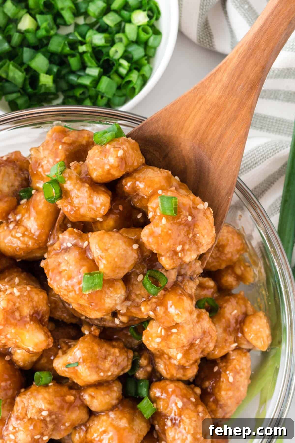 Sticky Teriyaki Cauliflower Bites with Sesame and Scallions 3 teriyaki cauliflower in a bowl topped with green onions and sesame seeds