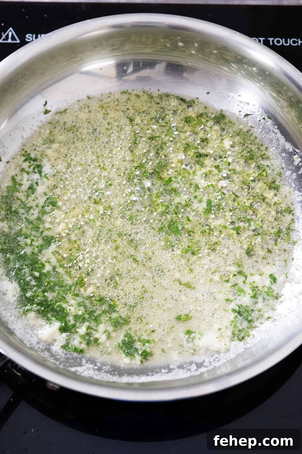 Crispy Air Fryer Garlic Parmesan Chicken Wings 6 garlic butter sauce with parsley simmering on low heat