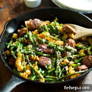 Sausage asparagus quinoa pasta in a cast iron skillet.