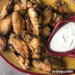 Crispy Chicken Wings with Tangy Feta Dipping Sauce 13 Chicken wings with a feta dipping sauce, in a yellow and red platter.