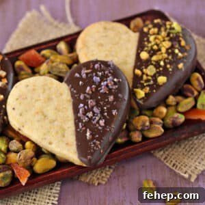 Crispy Pistachio Shortbread Cookies — Almond-Free Recipe 4 Close up of 3 Pistachio Shortbread Cookies on a bed of pistachios.